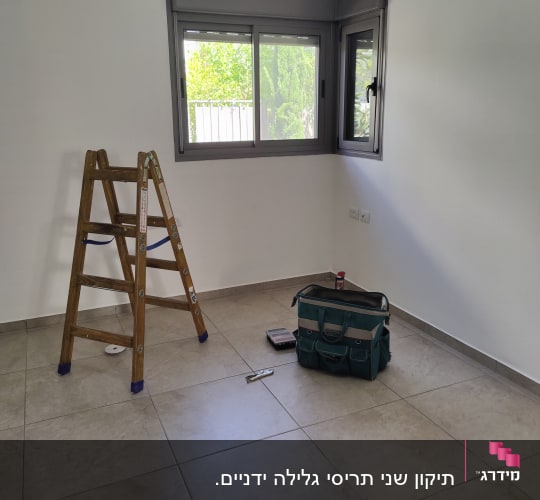 חלון עם תריסים אפורים פתוחים למחצה